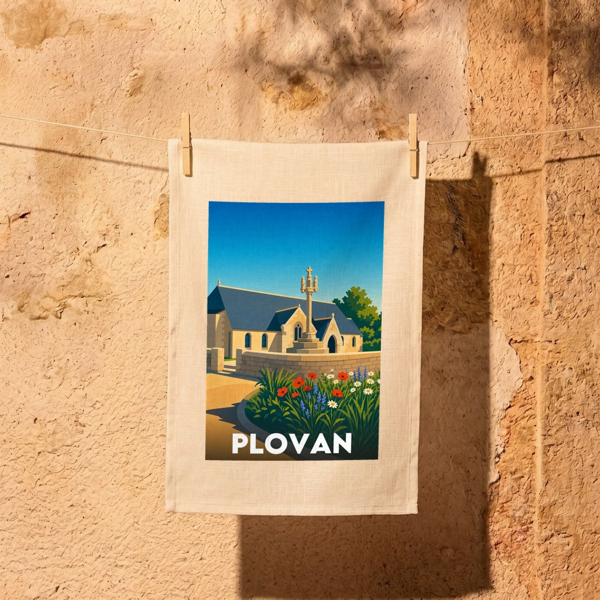 Torchon souvenir de la ville de Plovan avec une illustration stylisée de son église et de son calvaire.