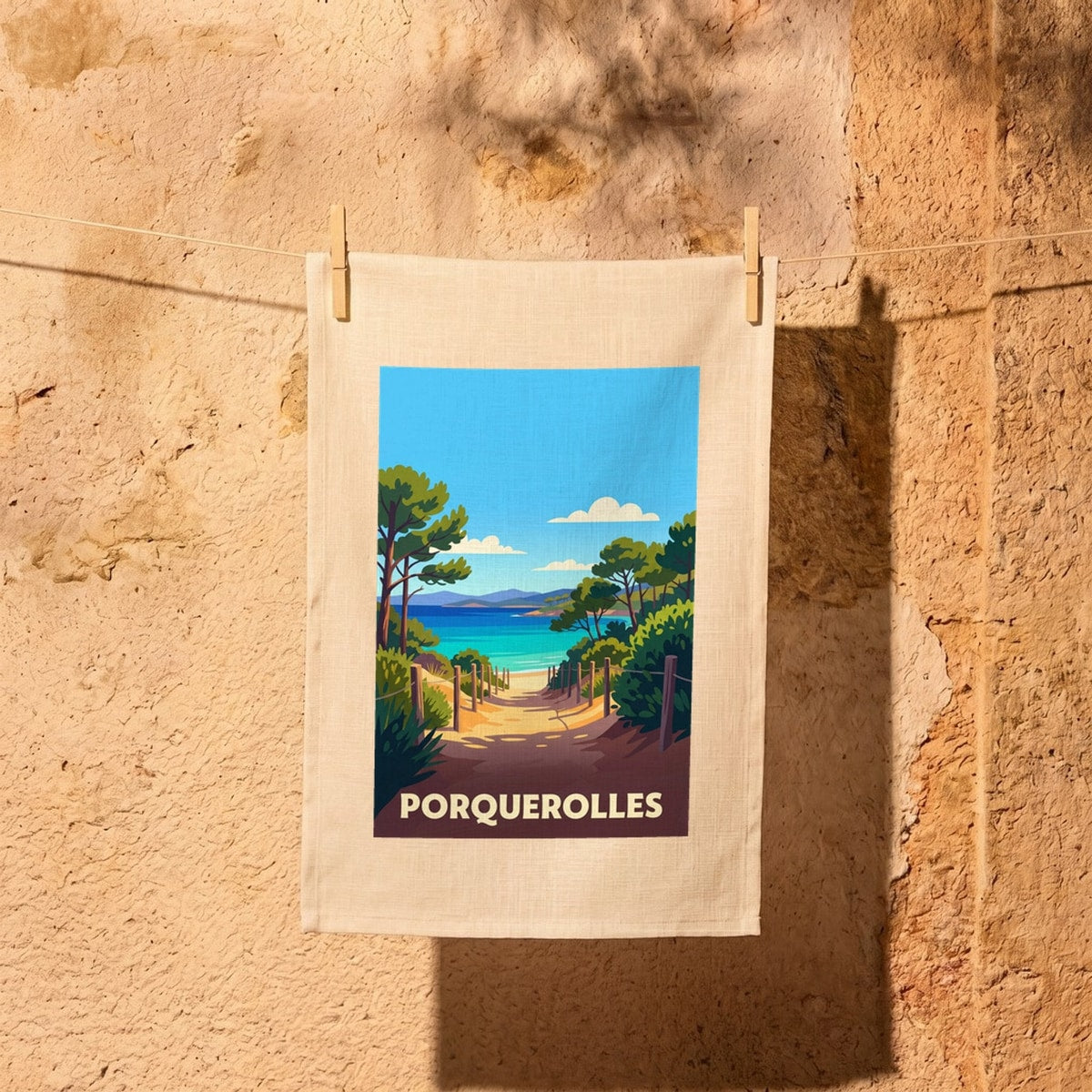 Torchon souvenir de Porquerolles avec une illustration stylisée de paysage côtier méditerranéen.