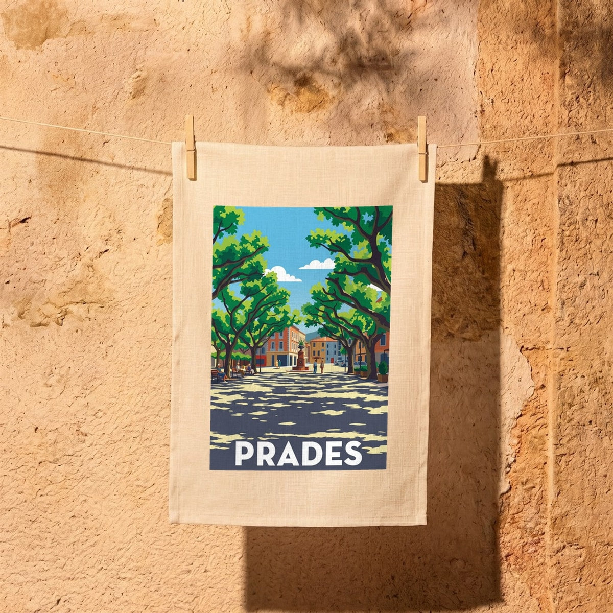 Torchon souvenir de la ville de Prades avec une illustration colorée et stylisée de sa place arborée.