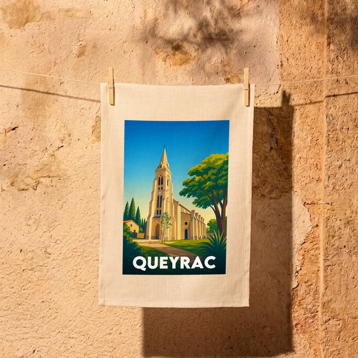 Torchon souvenir de la ville de Queyrac avec une illustration stylisée de son église.