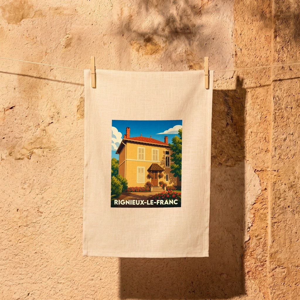 Torchon souvenir de la ville de Rignieux-le-Franc avec une illustration stylisée d'une maison ensoleillée.