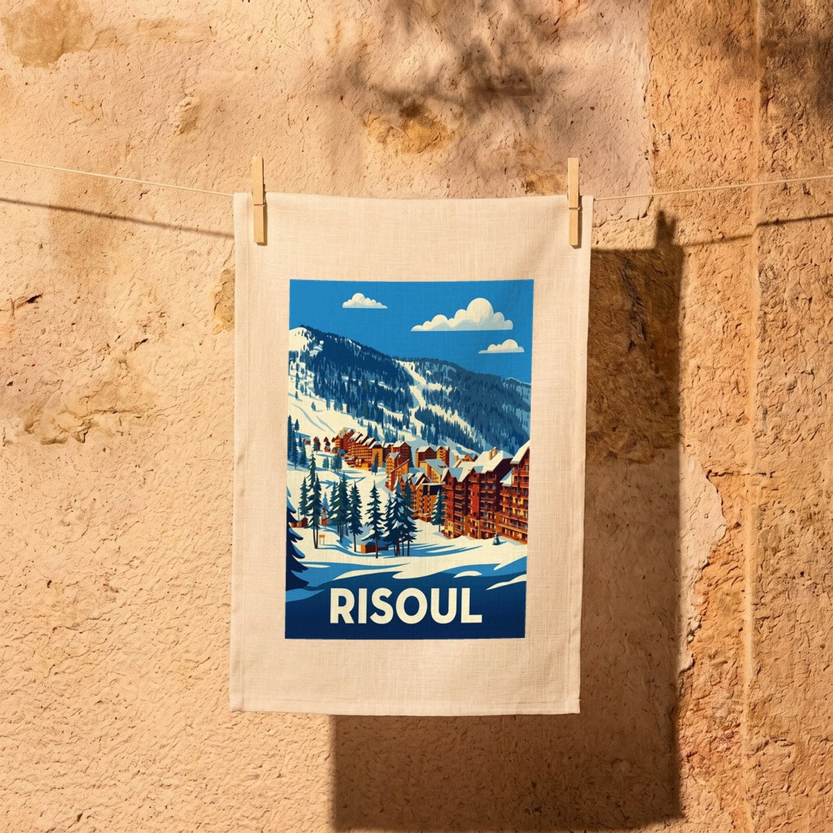 Torchon souvenir de la ville de Risoul avec une illustration stylisée d'un paysage de montagne enneigé.