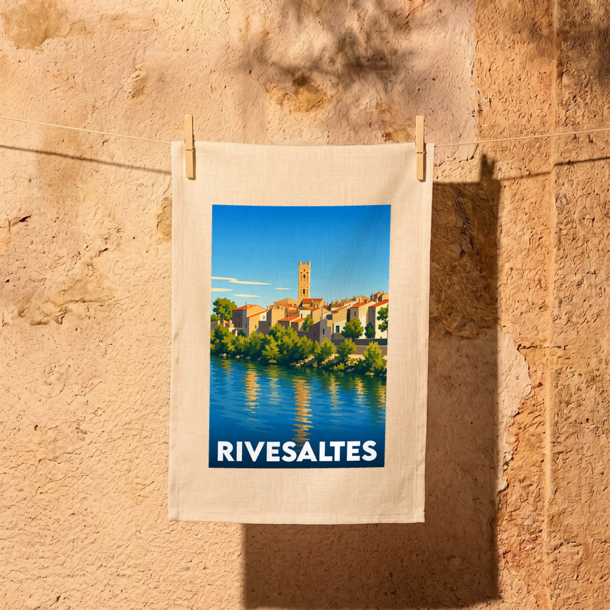 Torchon souvenir de la ville de Rivesaltes avec une illustration stylisée d'un paysage urbain au bord de l'eau.