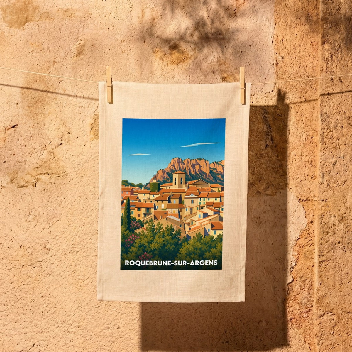 Torchon souvenir de la ville de Roquebrune-sur-Argens avec une illustration stylisée du village et de son rocher.