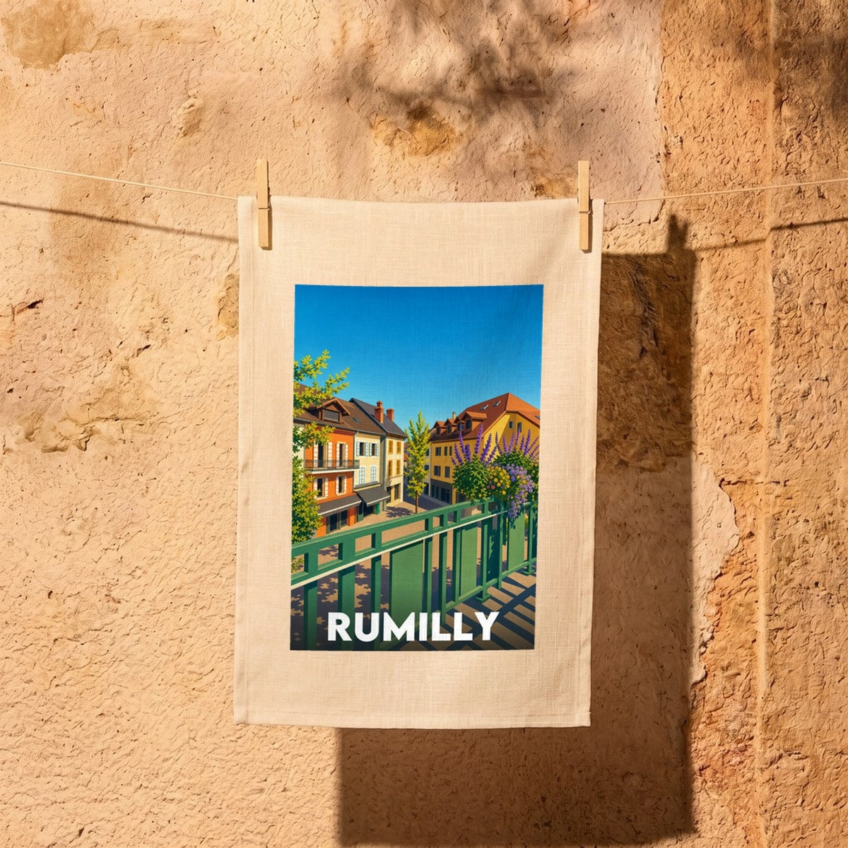 Torchon souvenir de la ville de Rumilly avec une illustration stylisée et colorée de ses bâtiments.