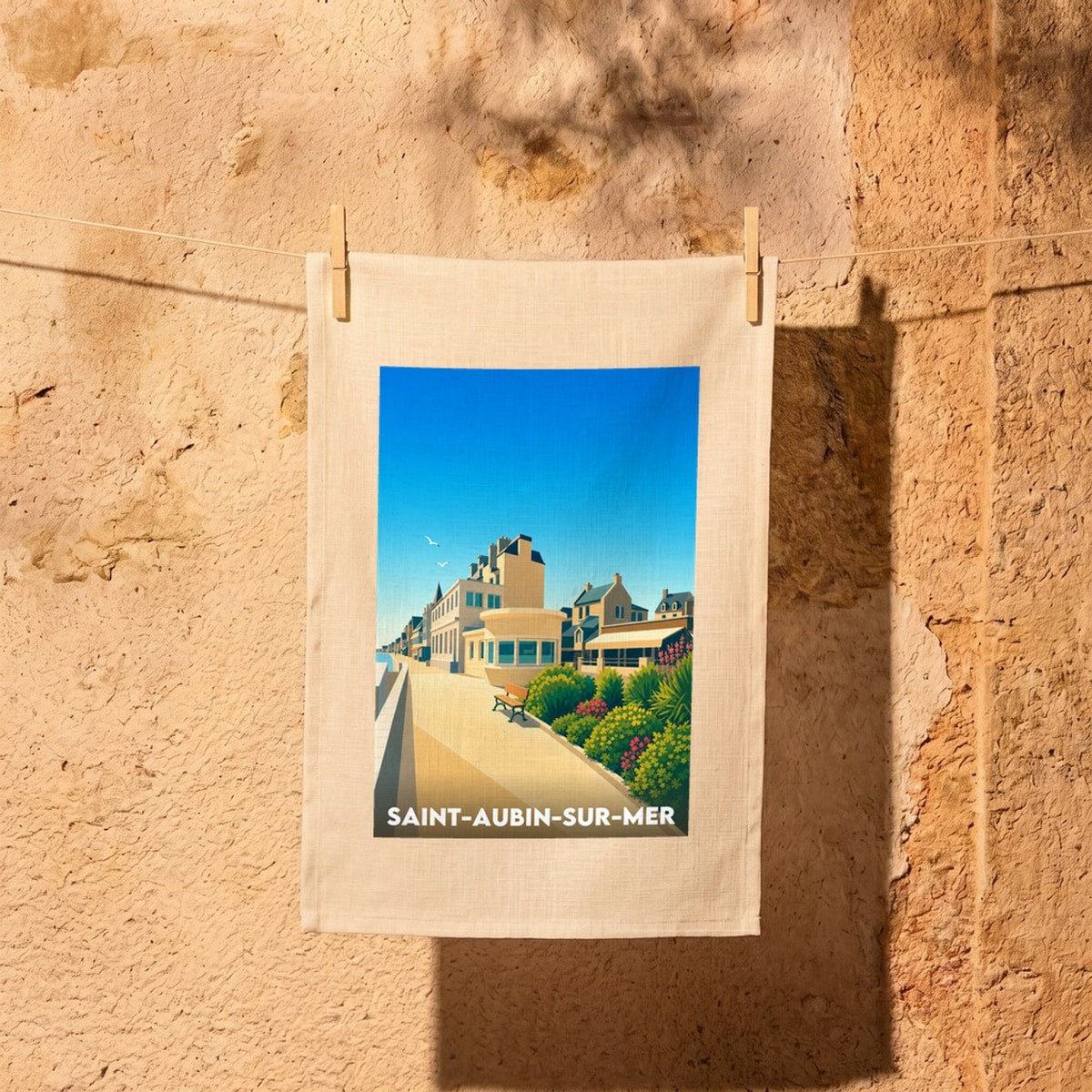 Torchon souvenir de la ville de Saint-Aubin-sur-Mer avec une illustration stylisée de son front de mer.