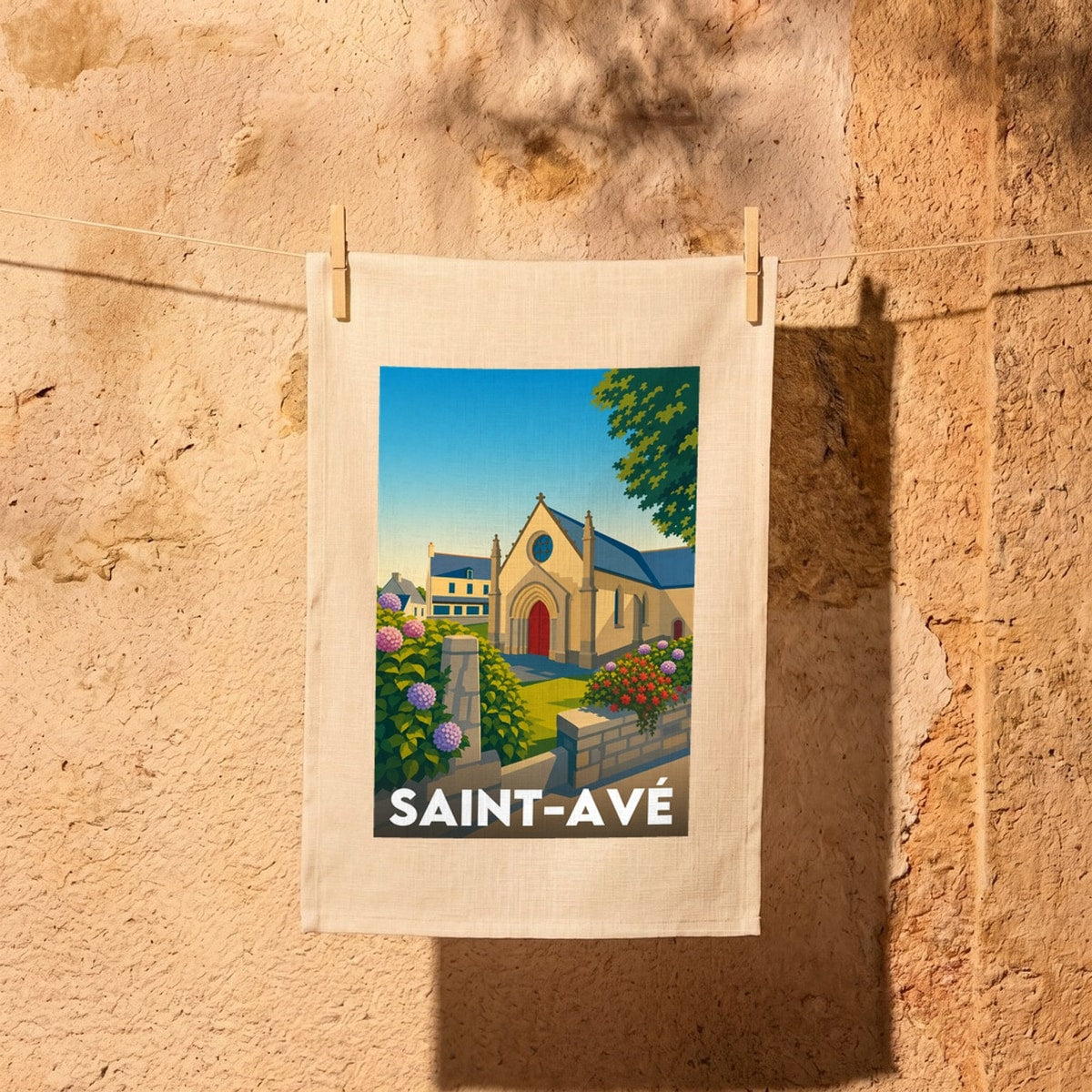 Torchon souvenir de la ville de Saint-Avé avec une illustration stylisée de son église et d'hortensias.