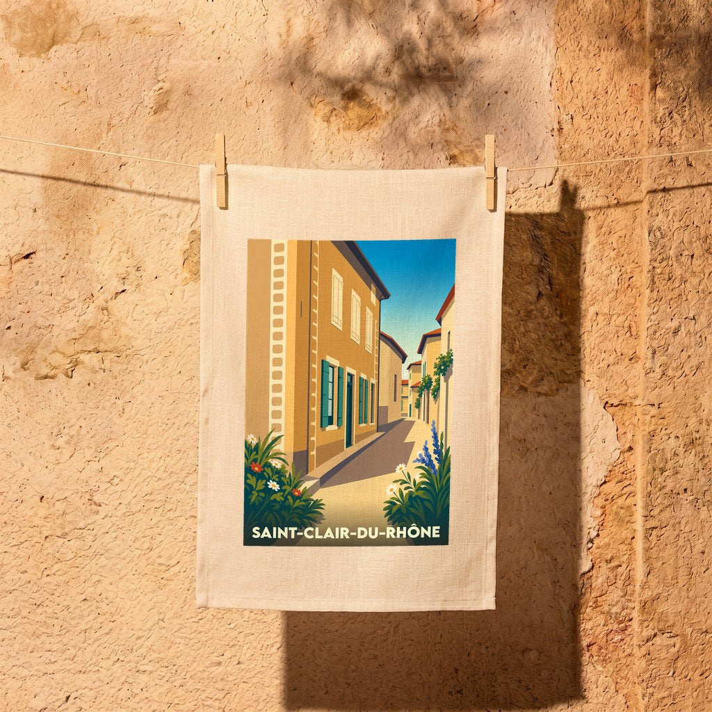 Torchon souvenir de la ville de Saint-Clair-du-Rhône illustré d'une scène de rue pittoresque et ensoleillée.