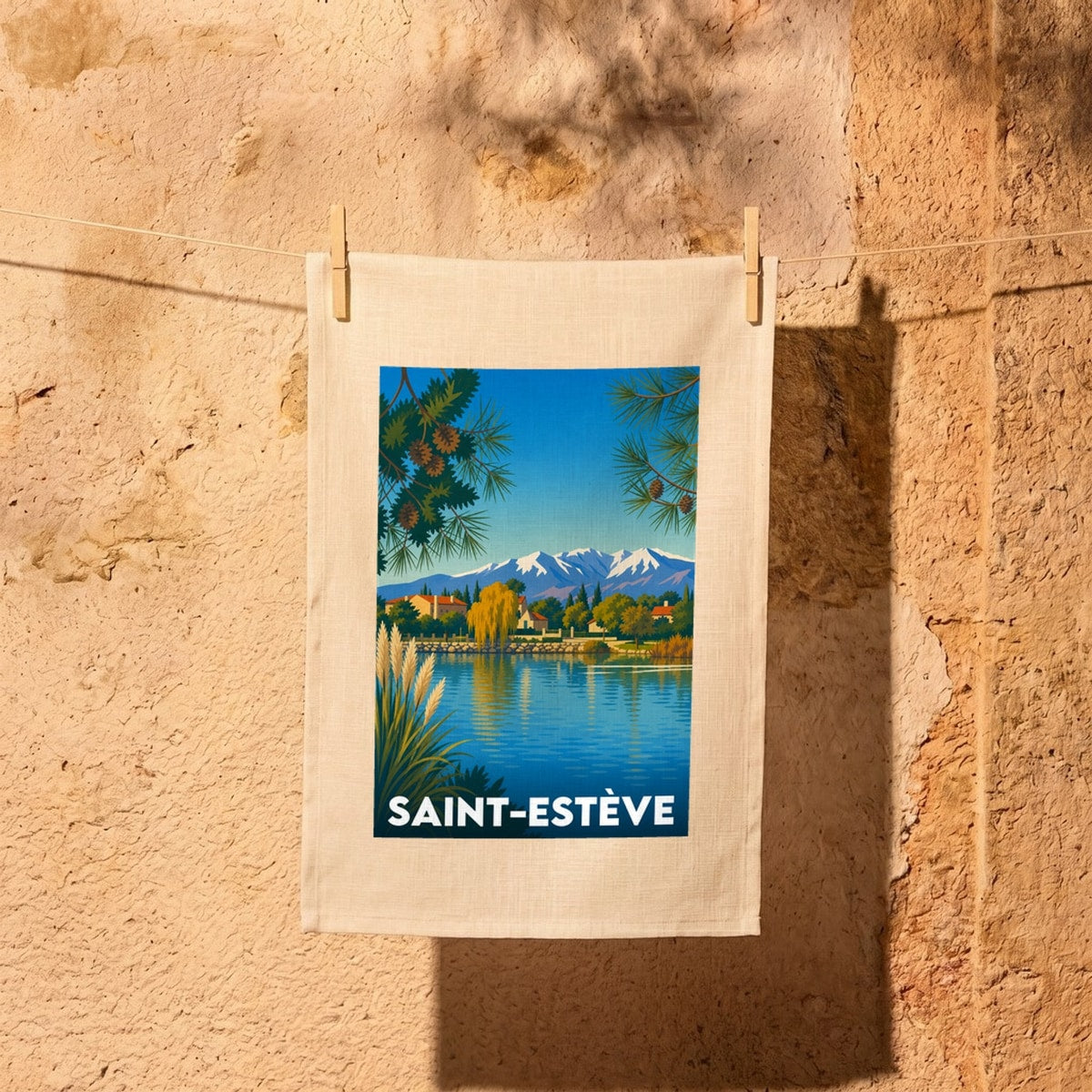 Torchon souvenir de la ville de Saint-Estève avec une illustration stylisée d'un paysage de lac et de montagnes.