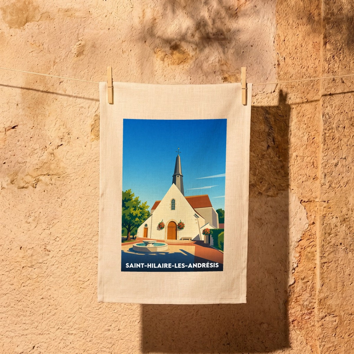 Torchon souvenir de la ville de Saint-Hilaire-les-Andrésis avec une illustration stylisée.