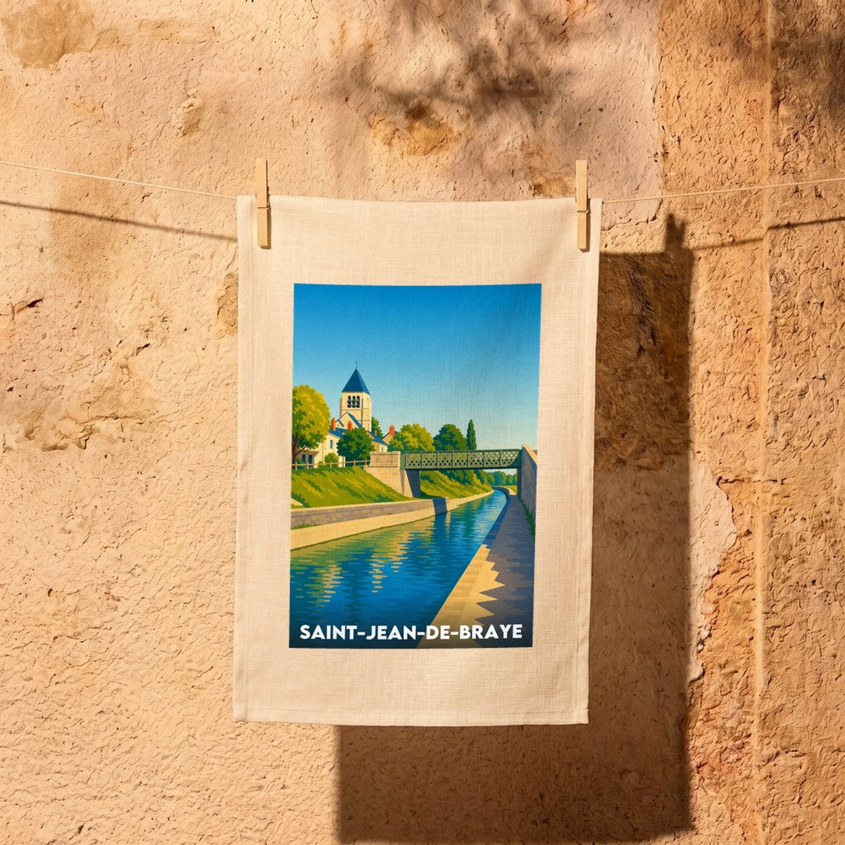 Torchon souvenir de la ville de Saint-Jean-de-Braye avec une illustration stylisée d'un canal et d'une église.