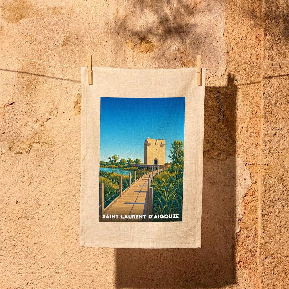 Torchon souvenir de la ville de Saint-Laurent-d'Aigouze avec une illustration stylisée.