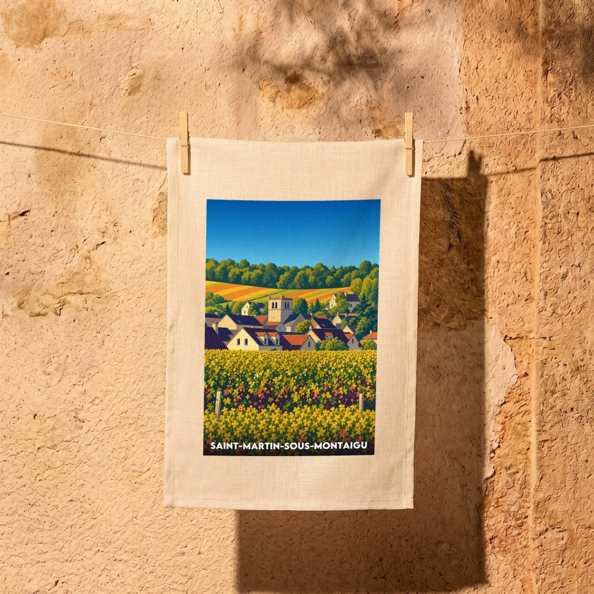 Torchon souvenir de la ville de Saint-Martin-sous-Montaigu avec une illustration stylisée du village et des vignobles.