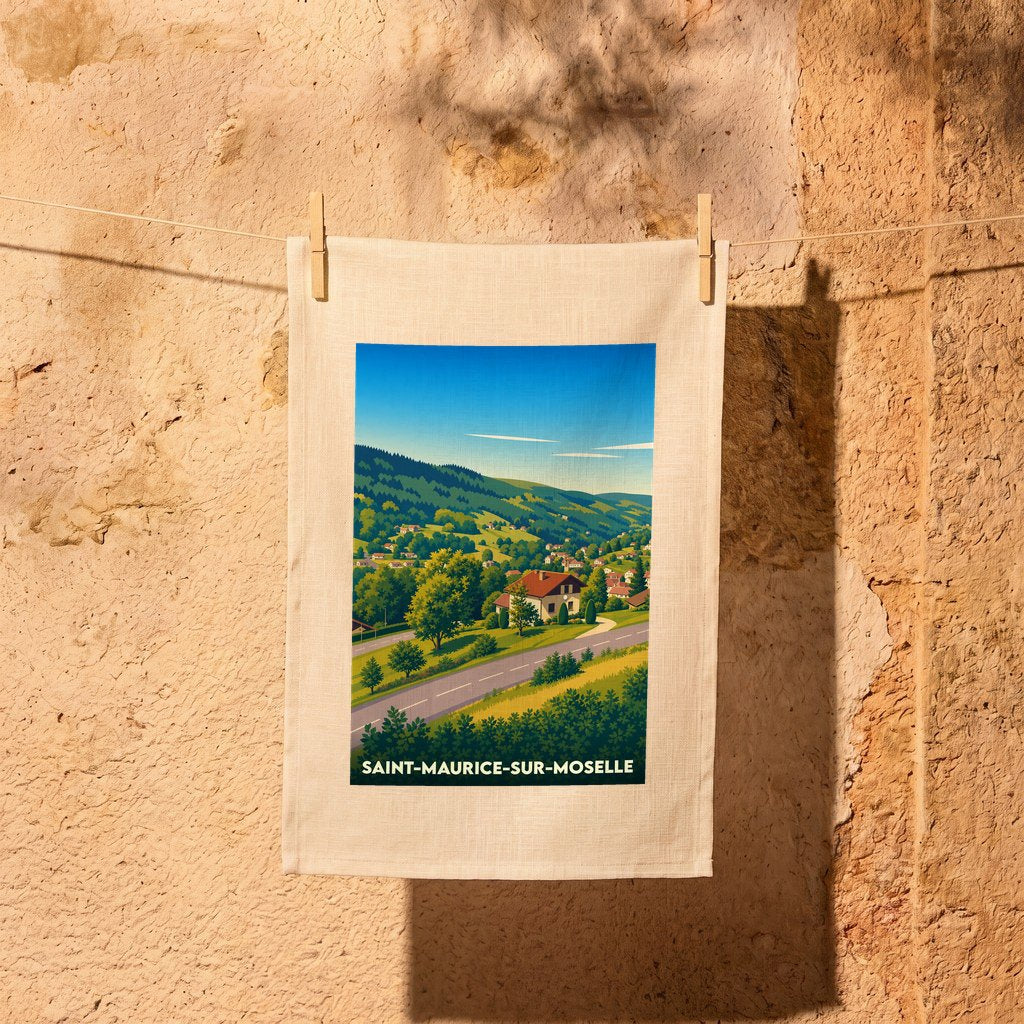 Torchon souvenir de la ville de Saint-Maurice-sur-Moselle avec une illustration de paysage de montagne stylisée.