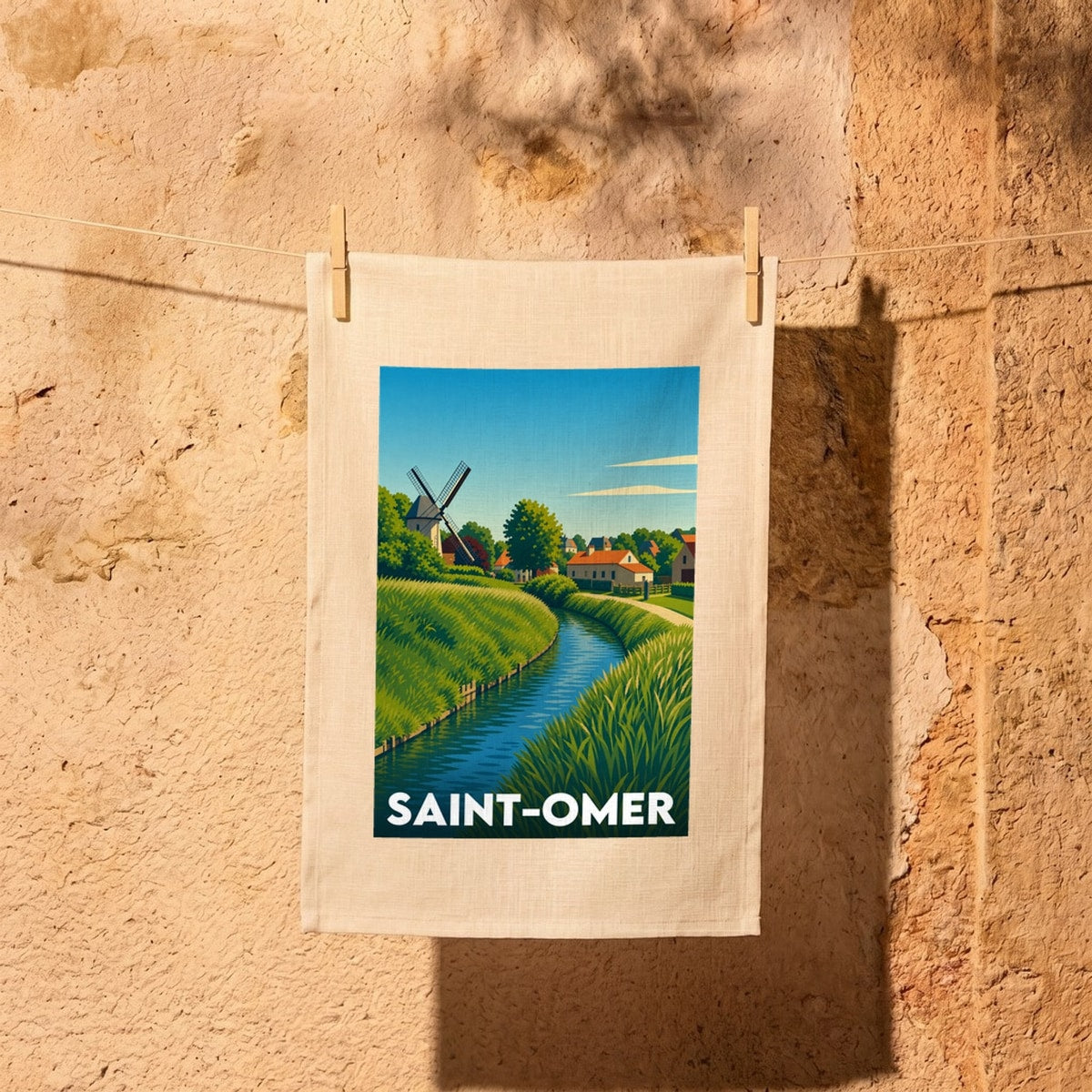 Torchon souvenir de la ville de Saint-Omer avec une illustration stylisée d'un moulin au bord de l'eau.