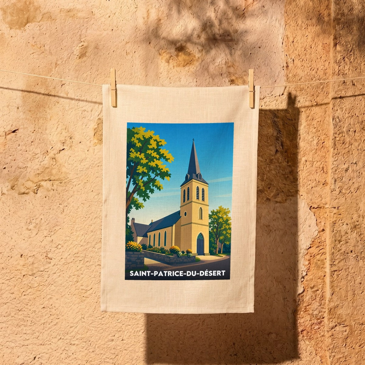 Torchon souvenir de la ville de Saint-Patrice-du-Désert avec une illustration stylisée de son église.