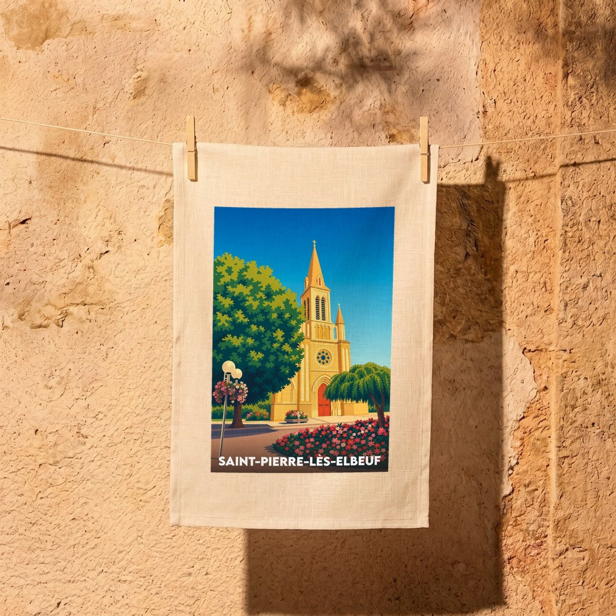 Torchon souvenir de la ville de Saint-Pierre-lès-Elbeuf illustré d'un dessin stylisé de son église et de sa végétation.