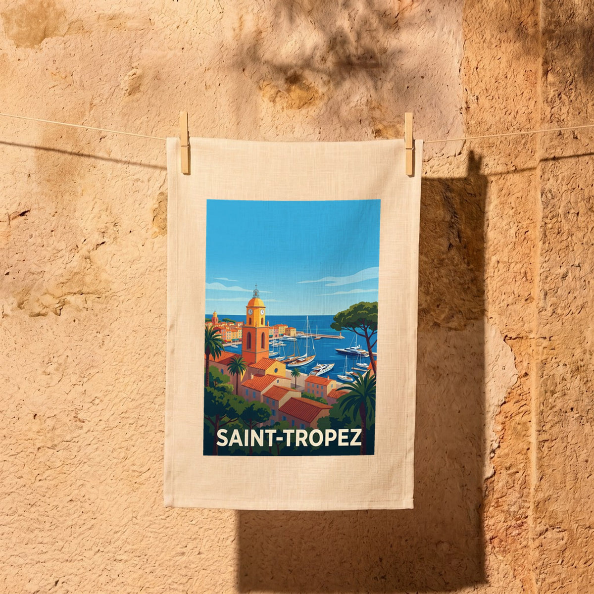 Torchon souvenir de la ville de Saint-Tropez avec une illustration stylisée du port et de son célèbre clocher.