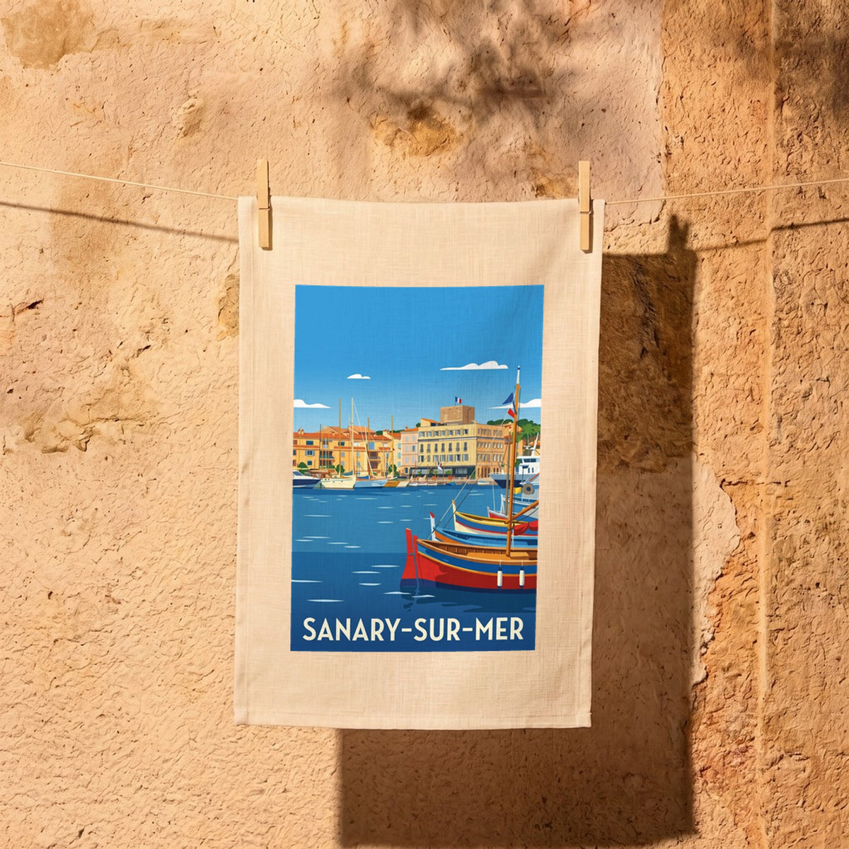 Torchon souvenir de la ville de Sanary-sur-Mer avec une illustration stylisée de son port.
