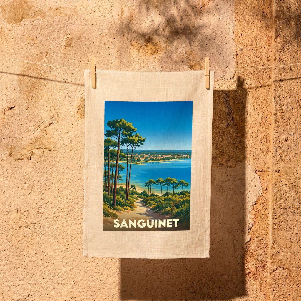 Torchon souvenir de la ville de Sanguinet avec une illustration stylisée d'un paysage de lac et de pins.
