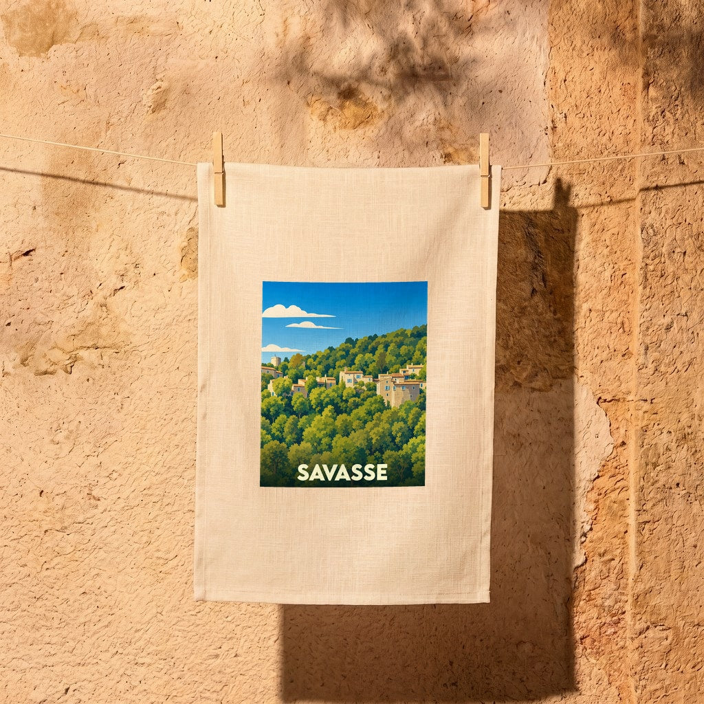 Torchon souvenir de la ville de Savasse avec une illustration stylisée d'un village perché dans la forêt.
