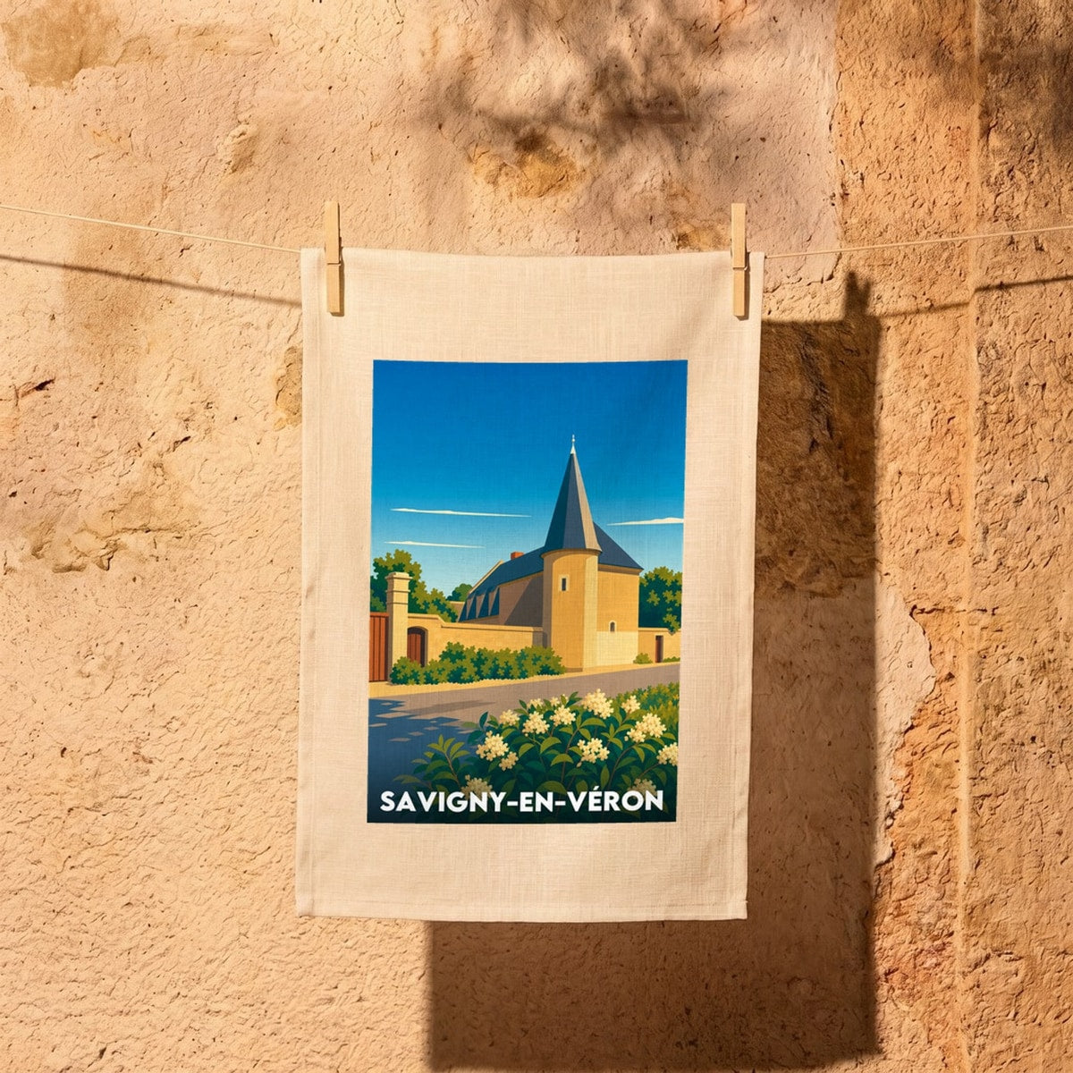 Torchon souvenir de la ville de Savigny-en-Véron avec une illustration stylisée de son patrimoine architectural.