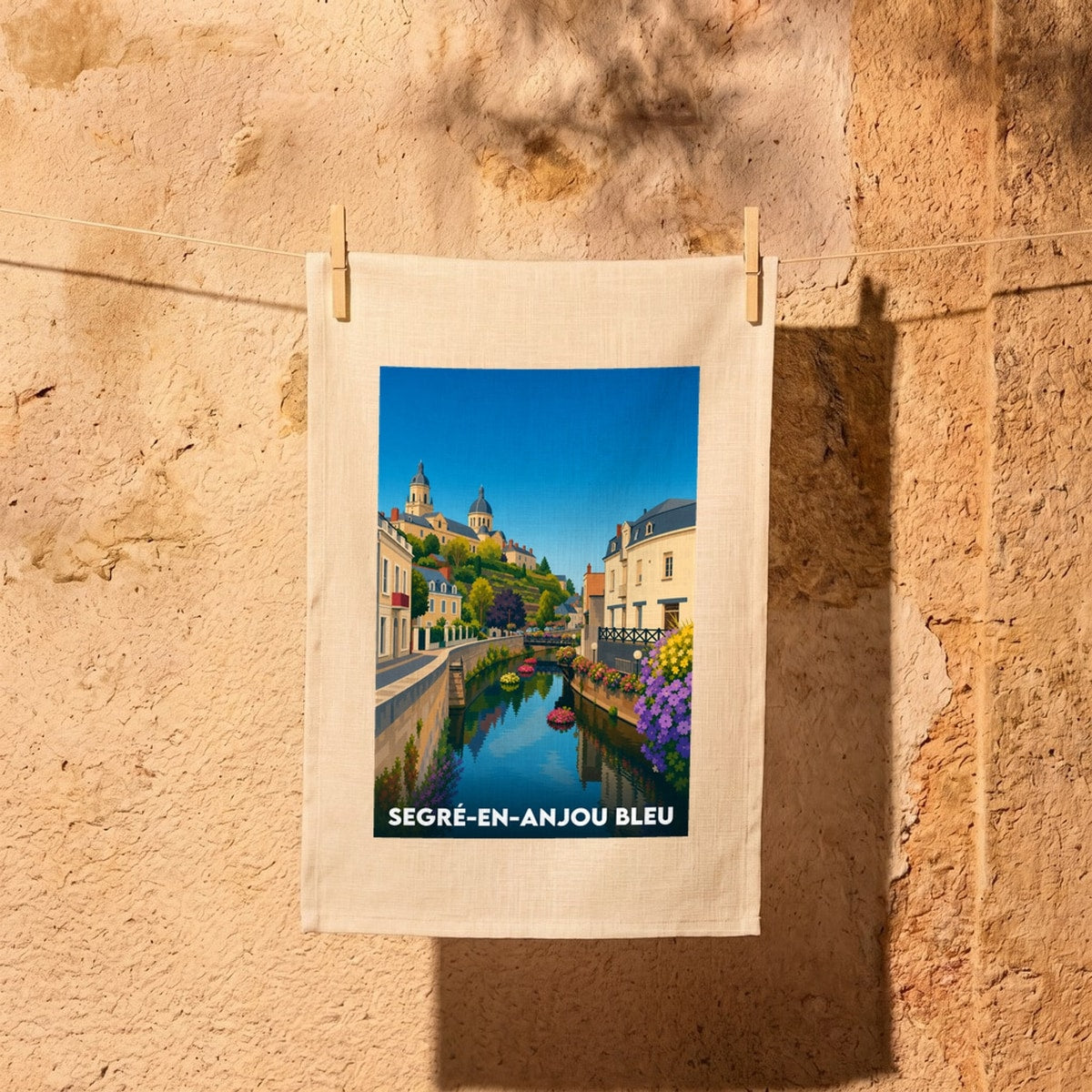 Torchon souvenir de la ville de Segré-en-Anjou Bleu avec une illustration paysagère stylisée.