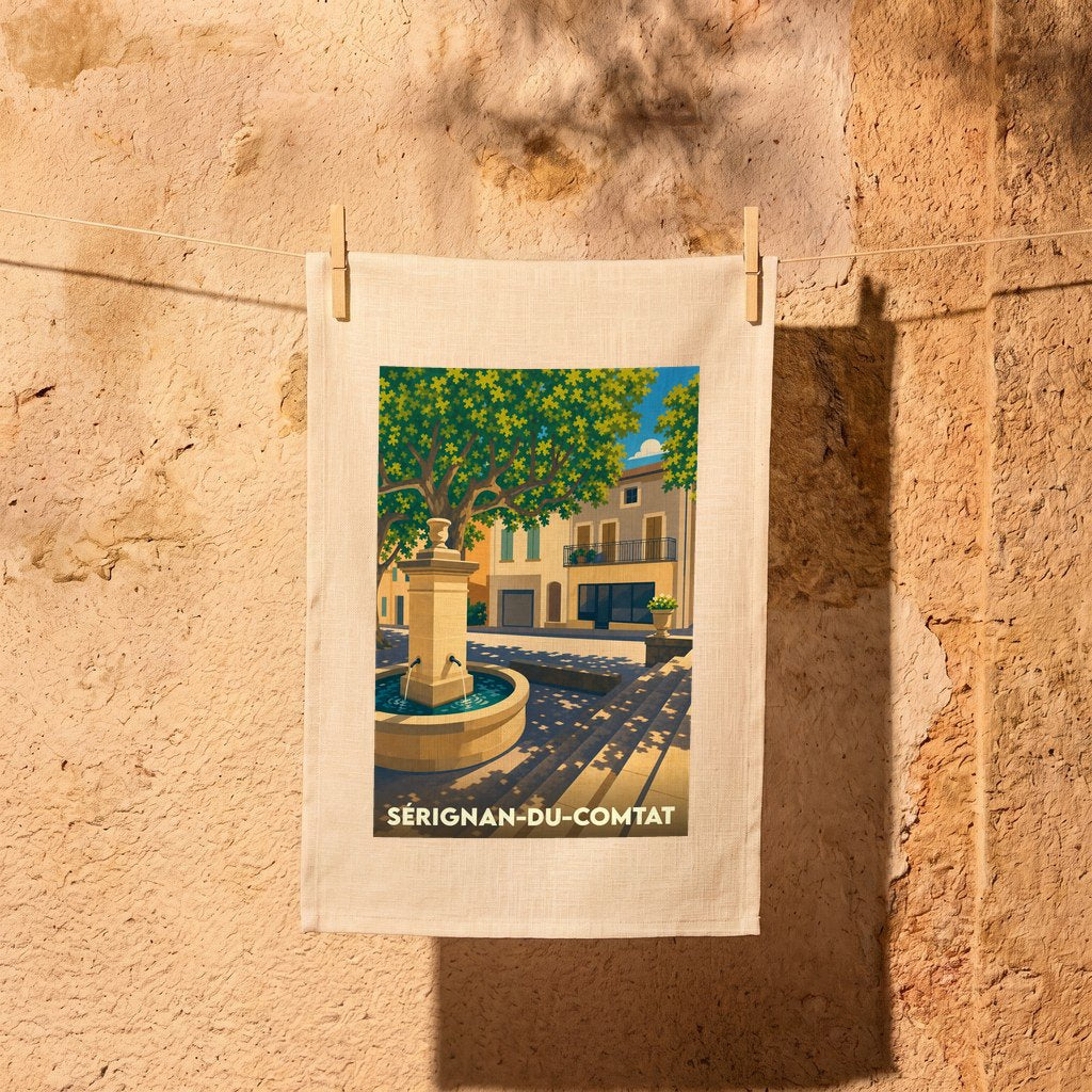 Torchon souvenir de Sérignan-du-Comtat illustré d'une scène de place provençale avec une fontaine.