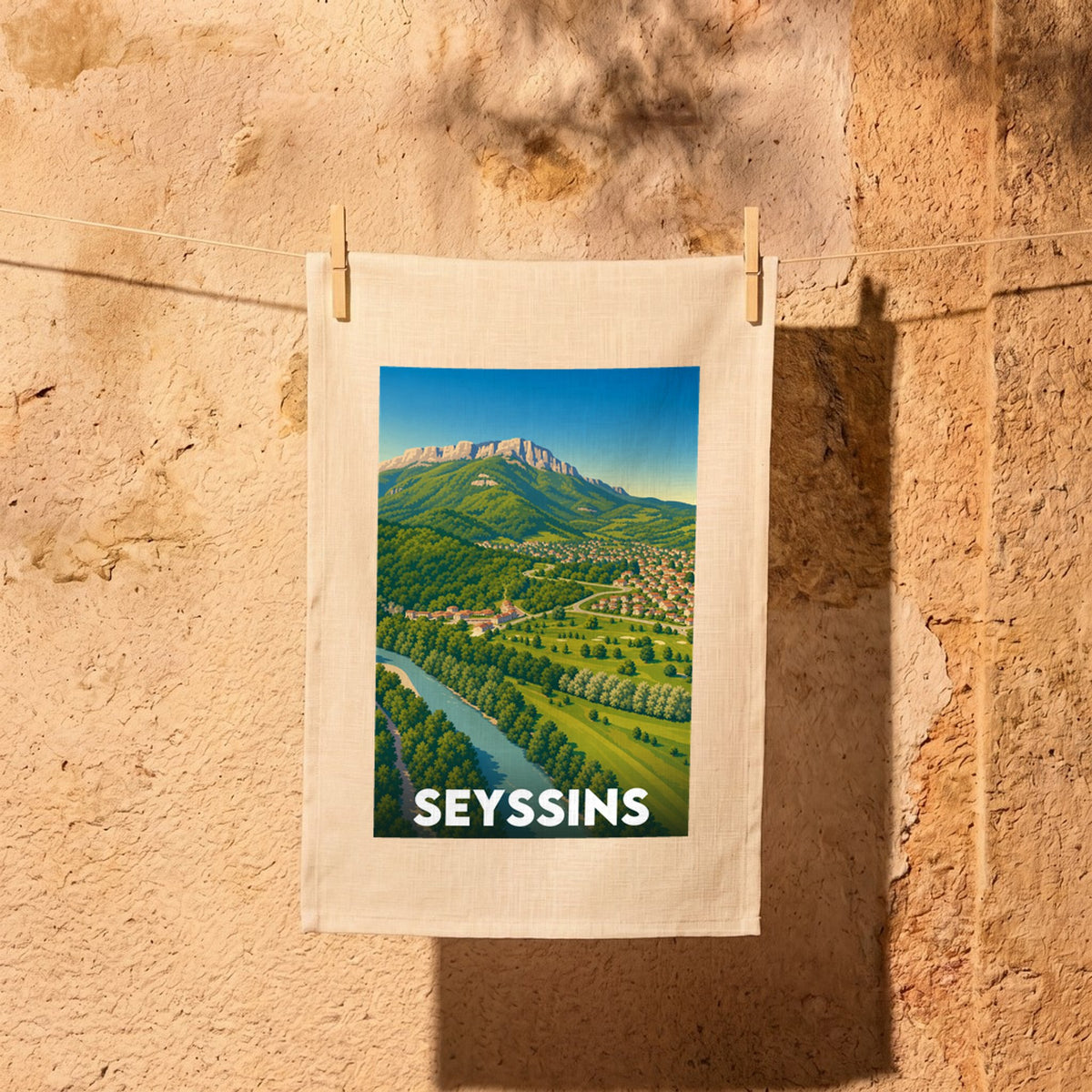 Torchon souvenir de la ville de Seyssins avec une illustration stylisée d'un paysage montagneux.