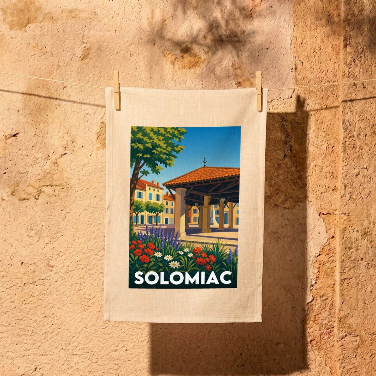 Torchon souvenir de la ville de Solomiac avec une illustration stylisée de sa place centrale.