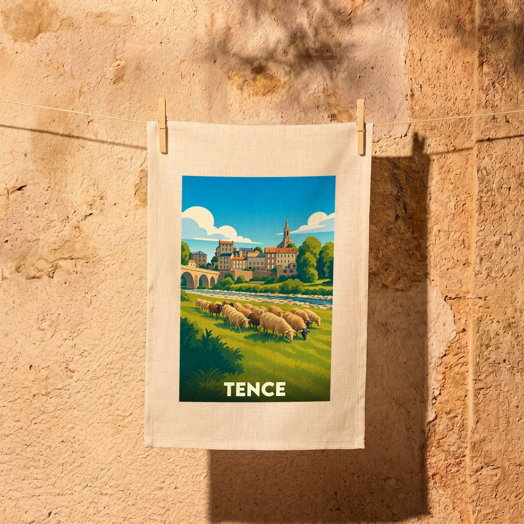 Torchon souvenir de la ville de Tence illustré d'un paysage pastoral avec des moutons et une vue sur le village.