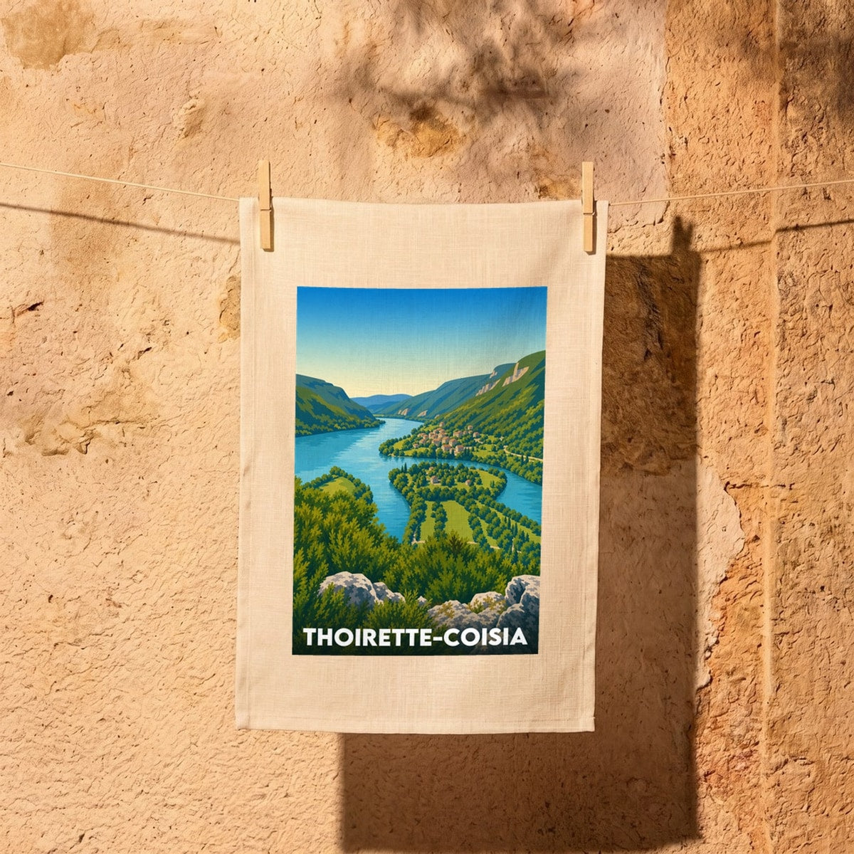 Torchon souvenir de la ville de Thoirette-Coisia avec une illustration stylisée d'un paysage de rivière et de montagnes.