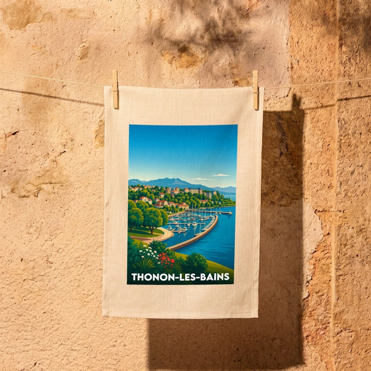 Torchon souvenir de la ville de Thonon-les-Bains avec une illustration stylisée de son port et des montagnes.