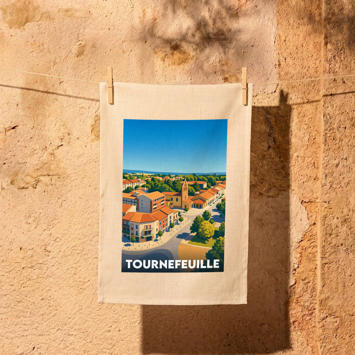 Torchon souvenir de la ville de Tournefeuille illustré d'une vue aérienne stylisée et colorée.