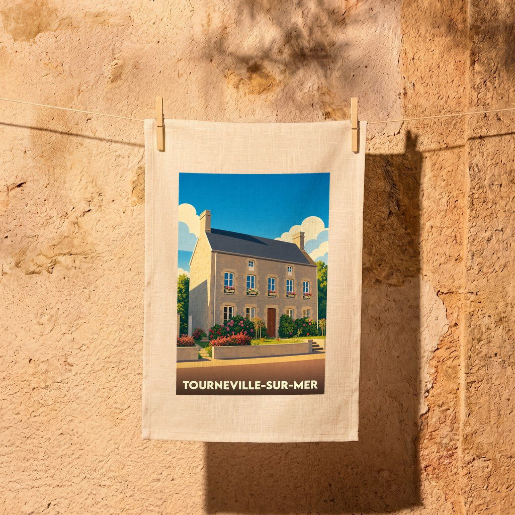 Torchon souvenir de Tourneville-sur-Mer illustré d'une maison côtière de style vintage, suspendu par deux pinces à linge.