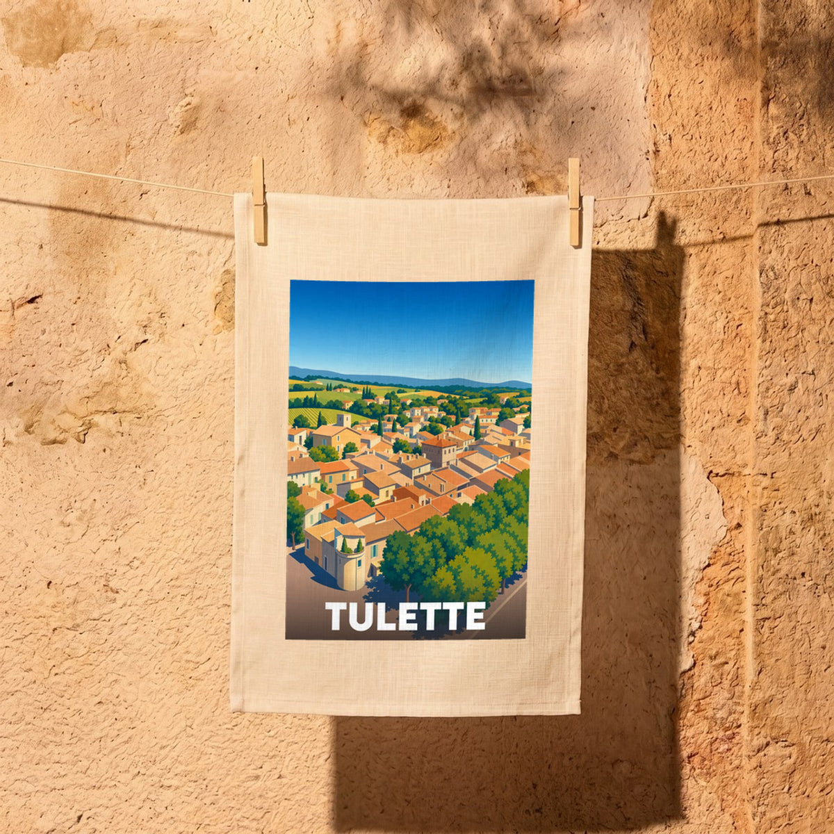 Torchon souvenir de la ville de Tulette avec une illustration stylisée de ses toits et de ses paysages.