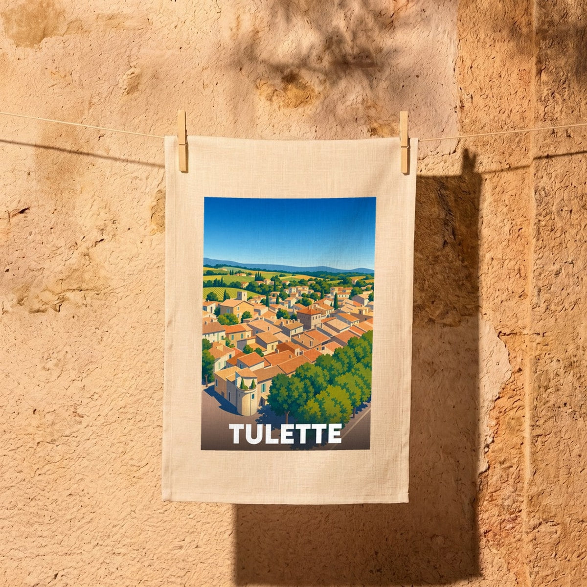 Torchon souvenir de la ville de Tulette avec une illustration stylisée de ses toits et de ses paysages.