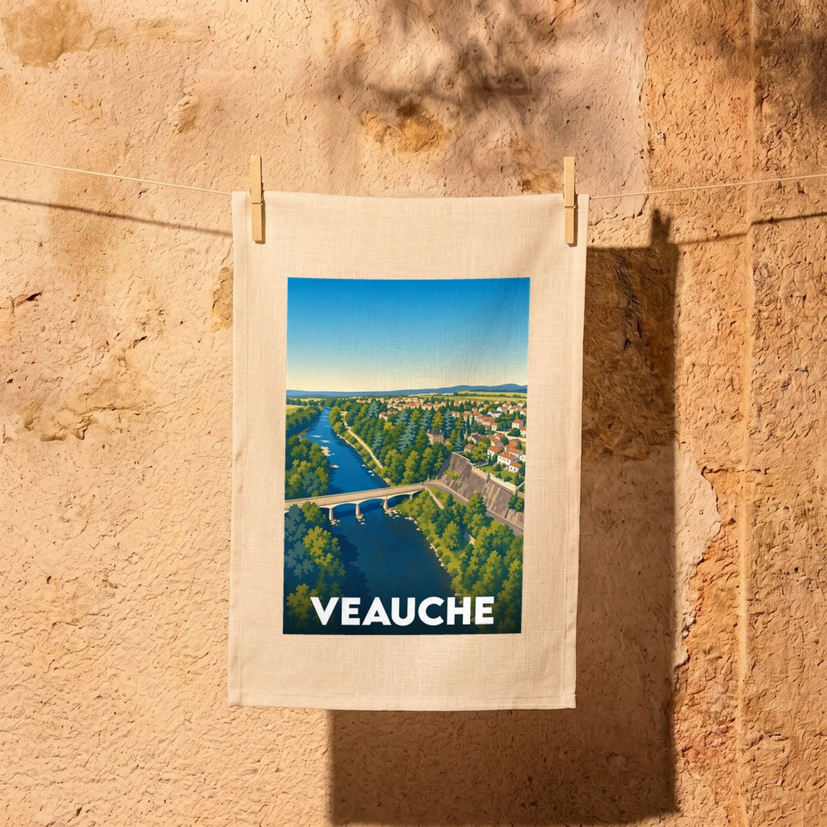 Torchon souvenir de la ville de Veauche avec une illustration stylisée représentant un pont sur la Loire.