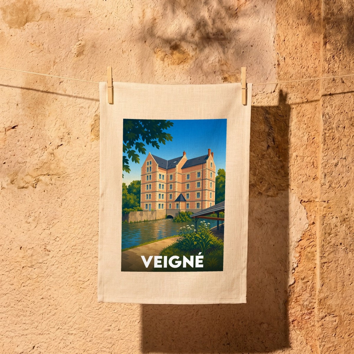 Torchon souvenir de la ville de Veigné illustrant un moulin stylisé au bord de l'eau.