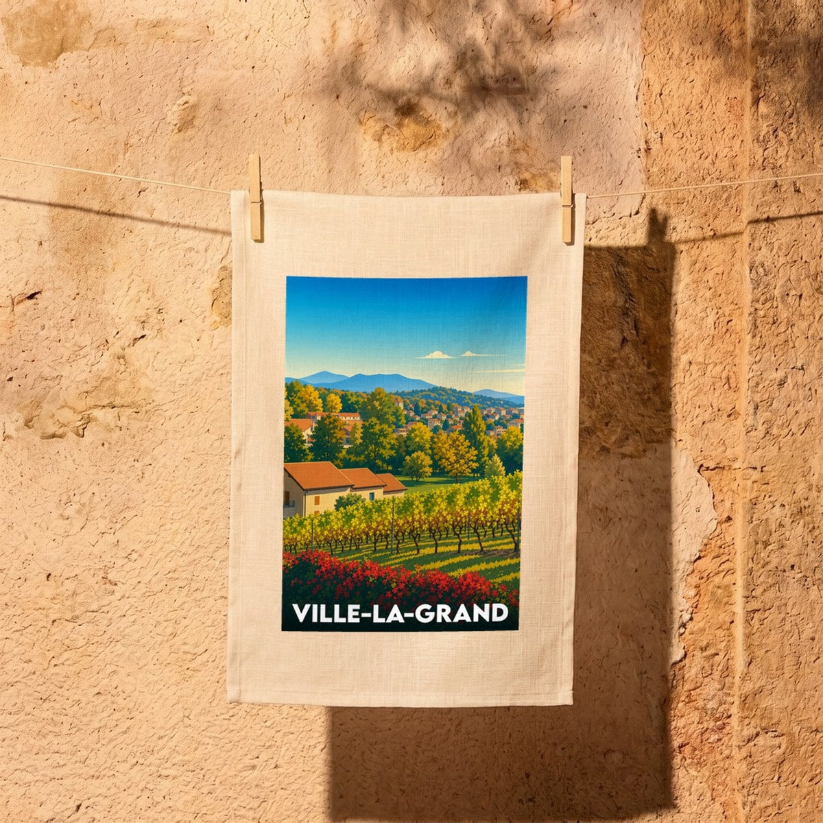 Torchon souvenir de la ville de Ville-la-Grand avec une illustration stylisée de paysages vallonnés et de vignobles.