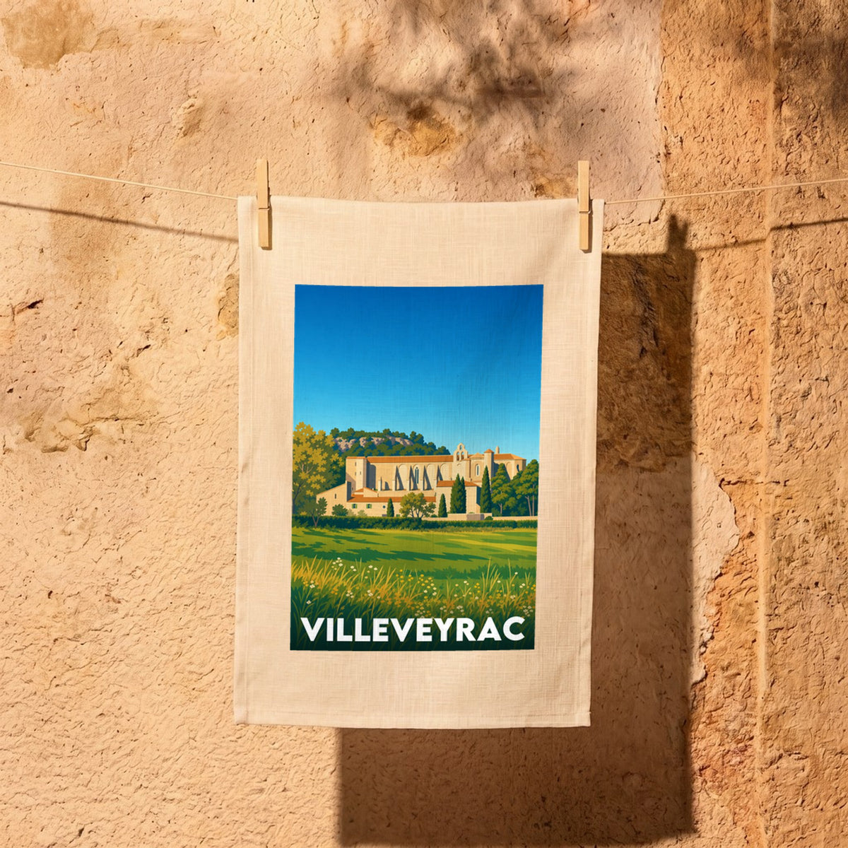 Torchon souvenir de la ville de Villeveyrac avec une illustration stylisée de ses paysages et de son patrimoine.