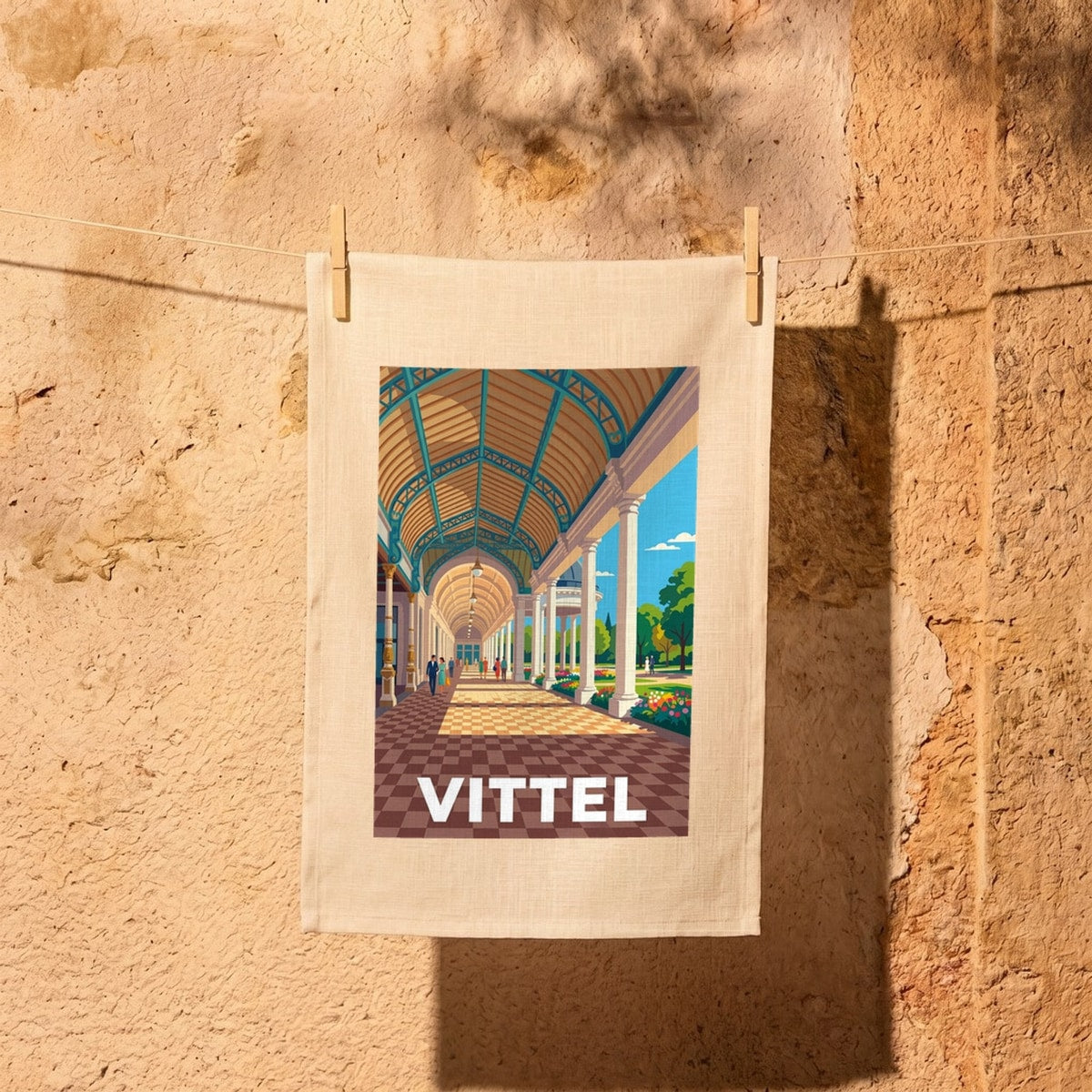 Torchon souvenir de la ville de Vittel avec une illustration stylisée de sa célèbre galerie thermale.