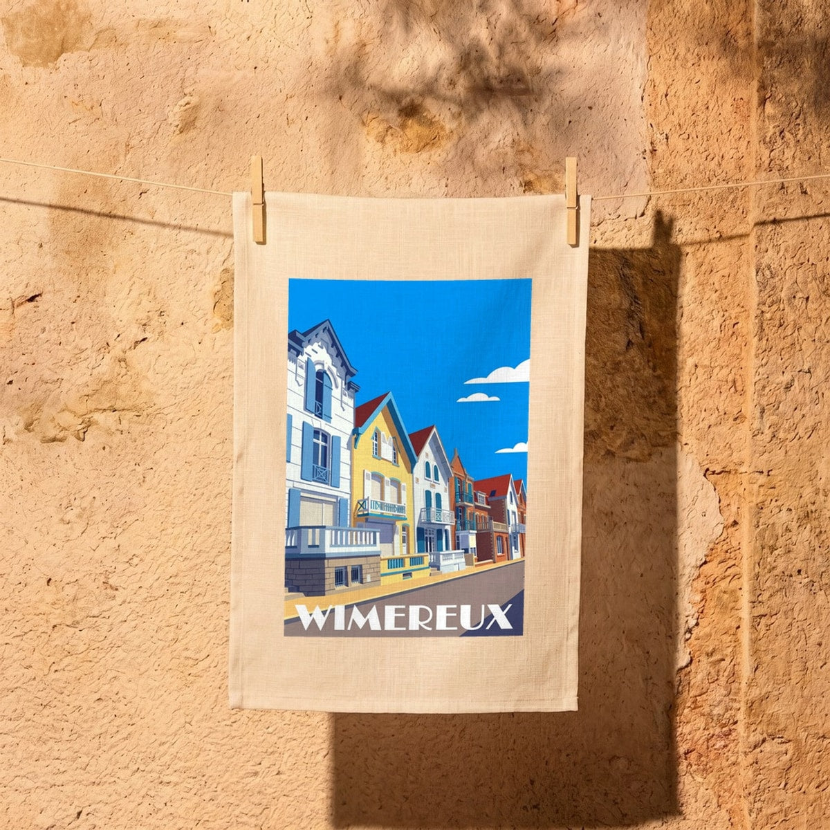 Torchon souvenir de la ville de Wimereux avec une illustration stylisée de villas colorées.