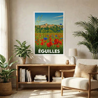 Affiche souvenir de la ville d'Éguilles illustrant un champ de coquelicots devant le village perché, présentée dans un intérieur moderne.