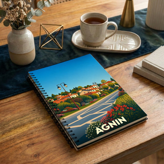 Carnet souvenir de la ville d'Agnin avec une illustration colorée et stylisée de son paysage urbain.