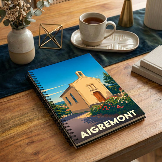 Carnet souvenir de la ville d'Aigremont avec une illustration stylisée d'une chapelle sous un ciel bleu.