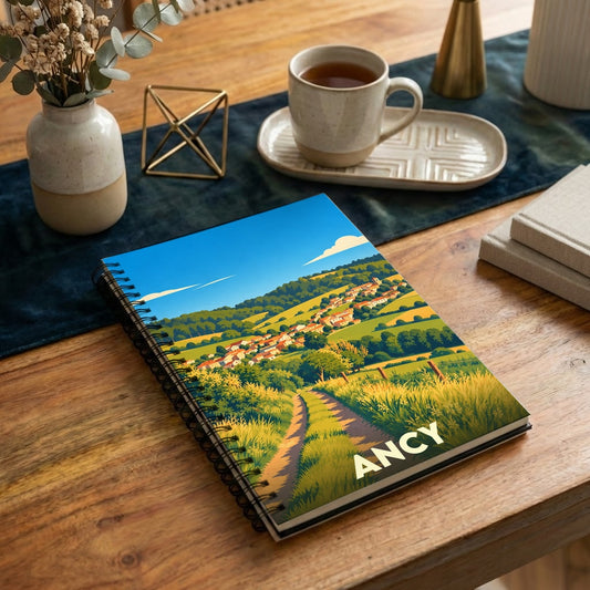 Carnet à spirale souvenir de la ville d'Ancy avec une illustration de paysage vallonné.