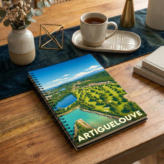 Carnet de notes souvenir d'Artiguelouve illustré d'un paysage stylisé mêlant golf, lacs et collines.