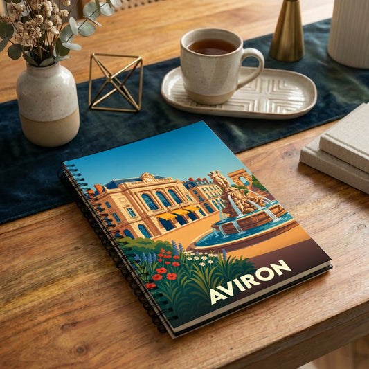 Carnet souvenir de la ville d'Aviron avec une illustration stylisée représentant une place animée et sa fontaine.