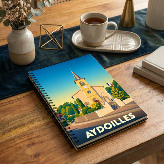 Carnet souvenir de la ville d'Aydoilles avec une illustration stylisée de son église.